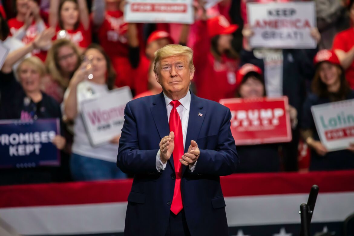 El presidente Trump aplaudiendo al entrar en el mitin en el Coliseo de Bojangle