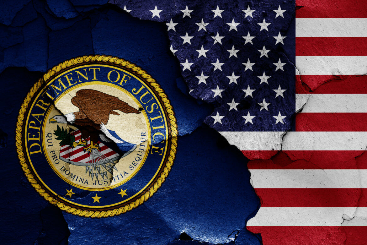 2A5TPBN flags of Department of Justice and USA painted on cracked wall